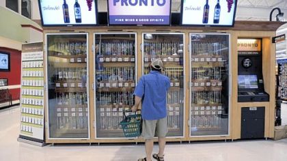 A shopper inspects wine offerings from the Pennsylvania Liquor Control Board's self-serve kiosk at a Harrisburg grocery store.