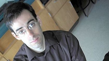 Dr. Michael Habib, assistant professor of biology at Chatham University, studies the wing strength of a variety of birds. Here he holds a dark green and blue emu egg from the university's collection.