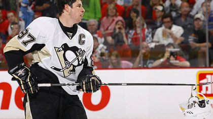 Penguins captain Sidney Crosby picks up his helmet after a scrum during Saturday's game at ScotiaBank Place in Ottawa.