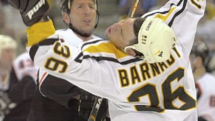 The Penguins Matthew Barnaby takes a right cross from Flyers Adam Burt in an undated photo.