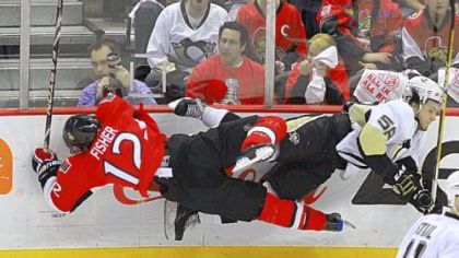 Ottawa's Mike Fisher, left, and the Penguins' Kris Letang crash off each other and the boards early Tuesday night in Ottawa.