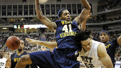 Pitt center Gary McGhee gets caught up against West Virginia forward John Flowers as he drives to the net in the first half.
