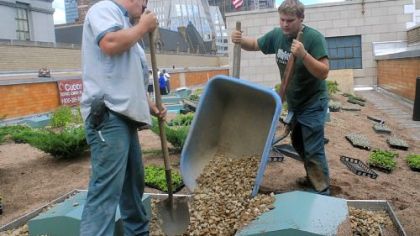 Justin Conner, left and Jared Kling, right, of Eisler Landscapes, work on the green roof atop the County Office Building last week.