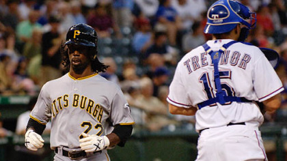 The Pirates' Andrew McCutchen scores a run during the first inning as Rangers catcher Matt Treanor looks on.