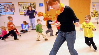 Mandy Turek leads her 4-year-old "cowboys" on a gallop around the classroom to the rodeo music of Aaron Copland at Noah's Ark Preschool in Peters. The school is planning to build a natural playground for the school's outdoor activities.
