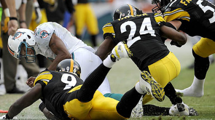 Dolphins quarterback Pat White takes a crushing hit from Steelers cornerback Ike Taylor and falls out out bounds. White suffered a concussion on the play.