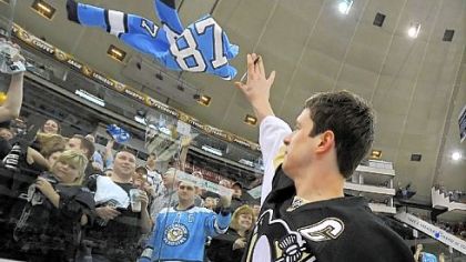 Sidney Crosby celebrates throws a jersey back to a fan that he signed at the end of Thursday night's victory against the New York Islanders.