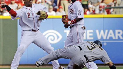 Reds shortstop Orlando Cabrera, left, throws to first base to complete a double play after forcing out the Pirates' Aki Iwamura at second base during the first inning of Wednesday's game at Great American Ballpark, in Cincinnati as second baseman Brandon Phillips watches. The Pirates' Neil Walker was out at first.