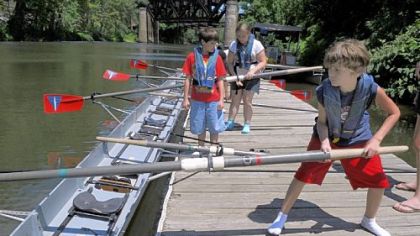 Austin Kline, 11, slides his oar into place as he gets his boat ready for a day of rowing at Washington's Landing arranged by the Summer Dreamers Academy.