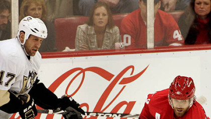 Red Wings forward Henrik Zetterberg makes an interior pass while being defended by  Penguins forward Michael Rupp during the third period.
