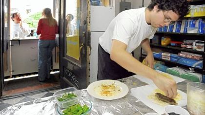 At the Kubideh Kitchen, Angel Gonzalez prepares kubideh sandwiches, an Iranian dish of spiced ground beef served with fresh basil, mint and onion on homemade Barbari bread with black sesame seeds.