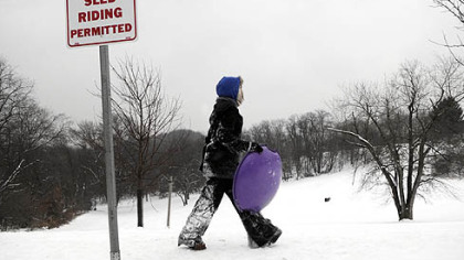 A sledder scouts for a spot to sled down the hill yesterday at Frick Park in Squirrel Hill.