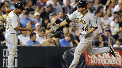 Pirates third base coach Tony Beasley, left, congratulates Garrett Jones as he runs towards home plate after a solo home run in the eight inning. Garrett Jones had two home runs.