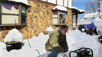 Gene Conti checks on the 2,500-watt generator powering appliances in his Stafford St. home in Pittsburgh's Sheraden neighborhood Monday afternoon. His home has been without electricity since Friday night.