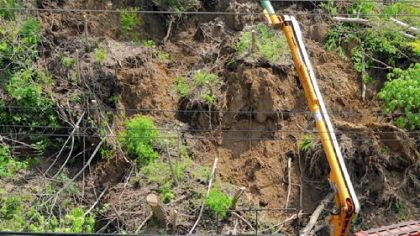 Workers from Fay-West Tree Management service remove trees from a landslide that partially closed Greentree Road below the Scott Towne Center shopping center. Heavy weekend rains are believed to have caused the landslide.