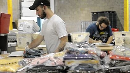 Jason Krivanek, left, of Scott and Nick Kizina of Polish Hill work on packaging and shipping orders for ModCloth at the company's distribution center on the South Side.
