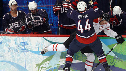 United States defensmean Brooks Orpik checks Switzerland forard Romano Lemm.