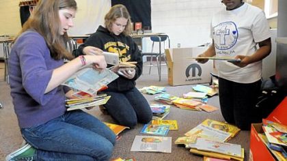 From left, eighth-grader Molly Wicker, 14, seventh-grader Aubrie Tarris, 12, and sixth-grader Ashley Bridges, 12, sort children's books Tuesday at Quaker Valley Middle School. Molly is leading a collection effort for the African Library project.