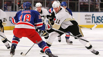 Penguins forward Jordan Staal plays the puck in front of his brother, Rangers defenseman Marc Staal, tonight at Madison Square Garden in New York.