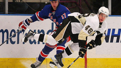 Penguins forward Tyler Kennedy dives for the puck against Rangers forward Brandon Dubinsky.