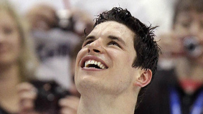 Canada's Sidney Crosby watches as the Canadian flag is raised during the medal ceremony.
