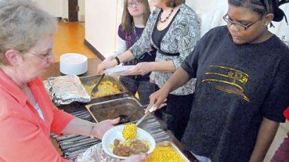 Emani Jones, right, helps serve lunch to seniors at the Crafton United Presbyterian Church. She's one of the special needs middle school students from the Pittsburgh Classical Academy who stock the food pantry and serve lunch at the church twice a month.