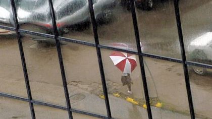 A pedestrian is reflected in the Red Cross building's glass on the Boulevard of the Allies, Downtown. The Red Cross is preparing to put the building up for sale.