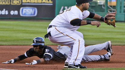 Pirates third baseman Pedro Alvarez waits for the late relay from right field as the White Sox's Alexei Ramirez slides safely into third.