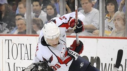 Penguins defenseman Alex Goligoski upends Capitals forward David Steckel.