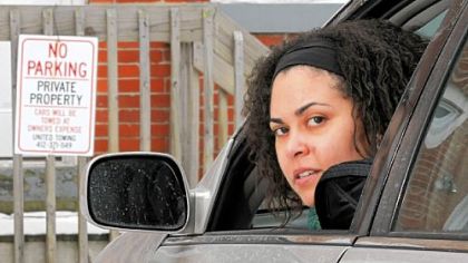 Heather Birch, of the East End, poses in her car in the parking lot behind her house where she is often blocked in by members of the nearby Mount Ararat Baptist Church despite several "No Parking" signs posted around the lot.