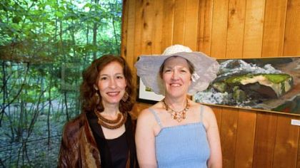 Artists Kathryn Stanko and Kitty Spangler stand next to Kitty Spangler's  acrylic painting "Bear Run Rocks."