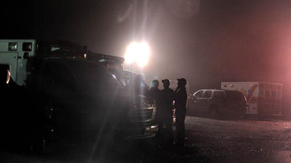 Rescue workers stand at an entrance to Massey Energy's Upper Big Branch mine in Raleigh County after an explosion there killed at least 25 people, Monday.