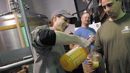 Joe Green, a volunteer with East End Brewing Co., pours a beer for Adam Cratty of Oakmont.