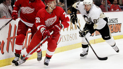 Red Wings forward Valtteri Filppula, left and defenseman Brian Rafalski try to get the puck out of their defensive end while being chased by Penguins captain Sidney Crosby.