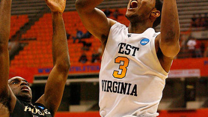 West Virginia's Devin Ebanks drives for a shot attempt against Washington's Quincy Pondexter.