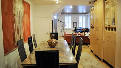 A large wax painting by artist Jennifer Johnston holds court in the Rushing's dining room, which wears the same custom maple cabinetry as the kitchen. The massive marble table came from a store in the West End.