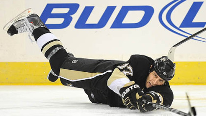 Penguins forward Mike Rupp handles the puck after being knocked to the ice by the Flyers forward Blair Betts.