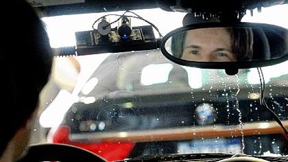 Spike Katora in the driver's seat of a Mini showing the camera placement on the window.