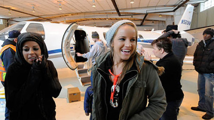 Jamie, left, and Ali McMutrie wait in the chill of an open Corporate Air hangar at Allegheny County Airport as the plane that will take them to Haiti is loaded with supplies for their BRESMA orphanage.