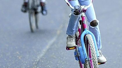 Bicyclist Stephen Marlette, of Regent Square, left, rides behind Raionda Jemison, 10, of East Liberty, on Friday at the Washington Boulevard bike oval, which was repaved last week.