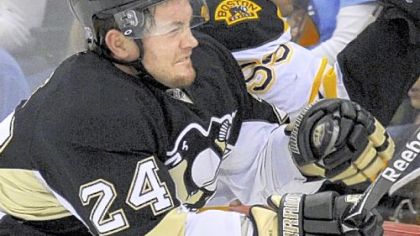 Matt Cooke, seen here checking Bruins' Johnny Boychuk early in Sunday's game, has built a reputation for gritty play.