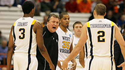 West Virgnia head coach Bob Huggins addresses his players during a timeout in the first half.
