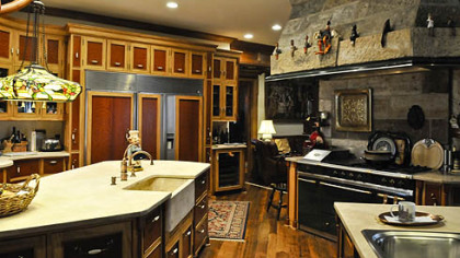 The kitchen flows into one large space detailed with curly cherry and handcrafted cabinets with butternut wainscot molding. Durango limestone counterops with a deep stone sink and three stainless steel sinks are also featured.