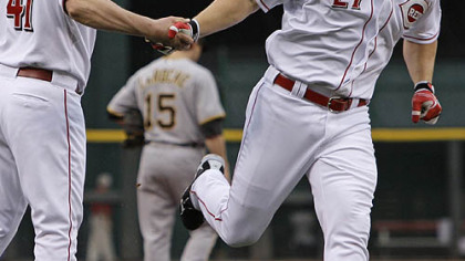 The Reds' Scott Rolen is congratulated by third base coach Mark Berry after hitting a three-run home run off Pirates starting pitcher Charlie Morton in the first inning.