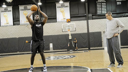 The Spurs' DeJuan Blair works on his free throws under the watch of assistant coach Chip Engelland at his team's practice facility in San Antonio.