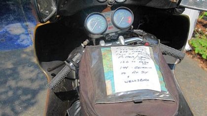 Garry Nelson boldly marks on note cards, left, intersections and towns of interest and attaches it to his motorcycle.