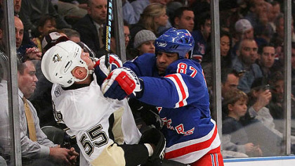 Penguins defenseman Sergei Gonchar is checked along the boards by Rangers forward Donald Brashear.