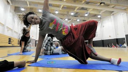 Shaquala Austin, a senior at Pittsburgh Brashear High School, holds her "dancer" pose  during a yoga  session at gym class.