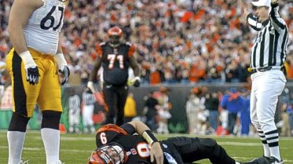 Pittsburgh Steelers' Kimo von Oelhoffen stands over Cincinnati Bengals quarterback Carson Palmer after Palmer injured his knee in the first half of their NFL playoff football game, Sunday, Jan. 8, 2006, in Cincinnati.