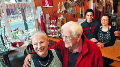 In her Annex Cookery store in Homestead, Judith Tener-Lewis stands in the arm of her husband, David Lewis, while her son, Daniel Steinitz, stands behind the counter with his wife, Ellie Gumlock. The kitchen store and neighboring Tin Front Cafe reside in a historic building on East Eight Avenue.